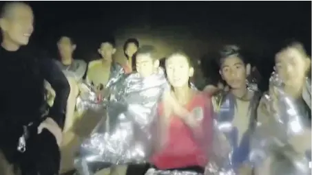  ?? SAKCHAI LALIT, AP | THAI NAVY SEAL VIA AP ?? Thai soccer-team boys, found to be mostly in stable condition, are covered in blankets in a partially flooded cave, in Mae Sai, Thailand. They were accompanie­d by U.S. Navy SEALs. Top, family members react after learning the boys are alive.