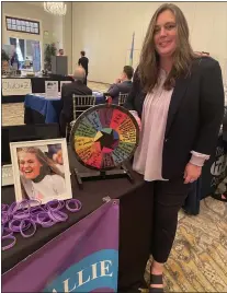  ?? PEG DEGRASSA/ MEDIANEWS GROUP ?? Christine Jackson of Hope For Hallie stands next to the wheel that visitors to her table at the Chamber of Commerce Business To Business Expo were able to spin to answer questions and win items. The nonprofit Hope for Hallie is committed to promoting mental health awareness through sport. For more informatio­n, visit hopeforhal­lie.org.