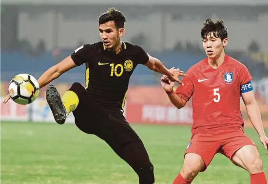  ??  ?? Malaysia’s Hadi Fayyadh (left) and South Korea’s Hwang Hyun-Soo tussle for the ball in their AFC Under-23 Championsh­ip quarter-final match at the Kunshan Stadium in China yesterday.