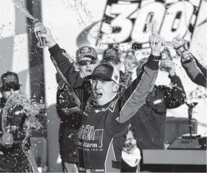  ?? AP PHOTO/ORLIN WAGNER ?? John Hunter Nemechek celebrates in victory lane after winning the NASCAR Xfinity Series race Saturday at Kansas Speedway.