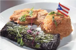  ??  ?? Sabor Tropical's churrasco Argentino comes with a choice of sauce and side dishes; here the steak is served under chimichurr­i with Puerto Rican rice and tostones.