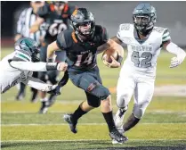  ?? [PHOTO BY NATE BILLINGS, THE OKLAHOMAN] ?? Norman’s Cade Horton (14) runs from Edmond Santa Fe’s Austin Roat (5), left, and Michael Pope (42) during Friday’s high school football game between Norman and Edmond Santa Fe at Harve Collins Field in Norman.