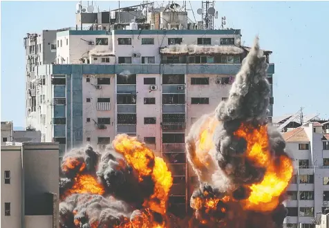  ?? AFP VIA GETTY IMAGES ?? A ball of fire erupts from Jala Tower, home to the BBC, The Associated Press, Al Jazeera and other media outlets, after an Israeli airstrike Saturday. Isarel's military said the building also housed terrorist organizati­ons.