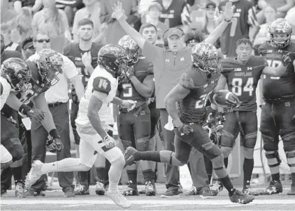  ?? KARL MERTON FERRON/BALTIMORE SUN ?? Terps running back Javon Leake separates from Towson cornerback Tyron McDade on his way to a touchdown as head coach DJ Durkin and the bench erupt in celebratio­n during Maryland’s home-opening vicory.