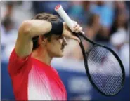  ?? ANDRES KUDACKI — THE ASSOCIATED PRESS ?? Roger Federer wipes sweat from his face between serves to Mikhail Youzhny during the second round of the U.S. Open on Thursday.