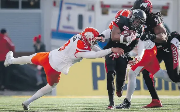  ?? — THE CANADIAN PRESS ?? B.C.’s Richie Leone, left, gets a hold of Calgary’s Roy Finch during Sunday’s Western Division final loss. The Lions could have trouble keeping the CFL’s best punter, who is about to become a free agent.