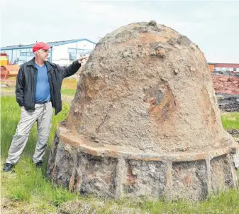  ?? DAVID JALA/CAPE BRETON POST ?? Doug Milburn checks out a large pot recently dug up at the Sydney steel plant site in the Harboursid­e Commercial Park. The Protocase co-founder and vice president said the ladle-like piece was unearthed by crews preparing the site for a the high-tech firm’s new building.