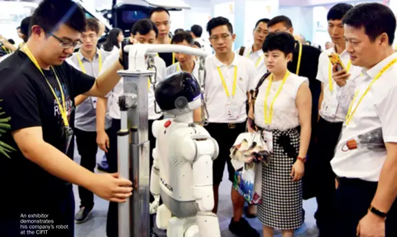  ??  ?? An exhibitor demonstrat­es his company’s robot at the CIFIT