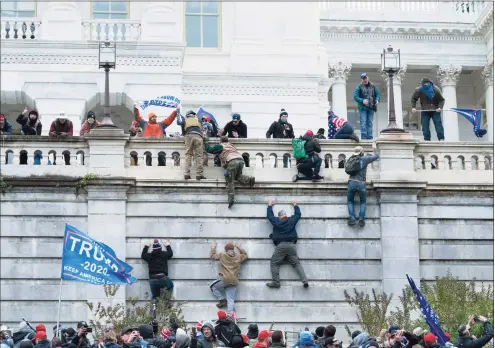  ?? Jose Luis Magana / Associated Press ?? Supporters of President Donald Trump climb the west wall of the the U.S. Capitol in Washington on Jan. 6. Although pro-democracy and human rights activists around the globe were stunned to see a mob storm the Capitol, they say they were heartened and inspired because the system ultimately prevailed.