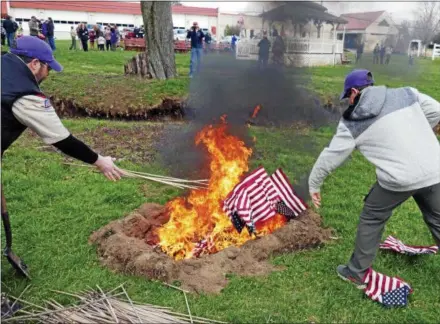  ?? FRAN MAYE – DIGITAL FIRST MEDIA ?? Boy Scouts from Troop 54 throw American flags into the fire during a flag-burning ceremony Sunday in Kennett Square.