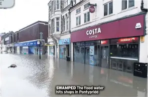  ??  ?? SWAMPED The flood water hits shops in Pontypridd