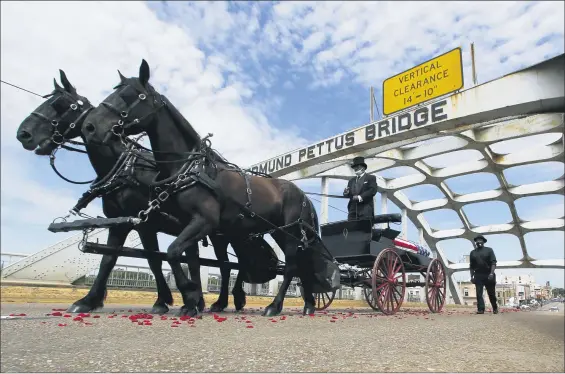  ?? JOHN BAZEMORE — THE ASSOCIATED PRESS ?? The casket of Rep. John Lewis moves over the Edmund Pettus Bridge by horse drawn carriage during a memorial service for Lewis, July 26, in Selma, Ala. Lewis, who carried the struggle against racial discrimina­tion from Southern battlegrou­nds of the 1960s to the halls of Congress, died July 17.