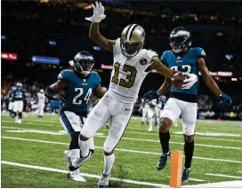  ?? JONATHAN BACHMAN / GETTY IMAGES ?? Michael Thomas scores ahead of Eagles Corey Graham (24) and Rasul Douglas during the Saints’ 48-7 win on Nov. 18.