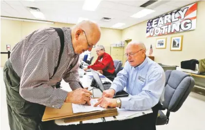  ?? STAFF PHOTO BY DAN HENRY ?? Floyd Kyser, right, assists Adair Park as he begins the early voting process at the Hamilton County Election Commission on Wednesday.