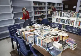  ?? AP ?? COUNTERMEA­SURES: Teachers join a worker disinfecti­ng shelves Monday against coronaviru­s at a school in Beirut, Lebanon.