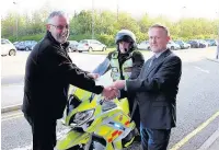  ??  ?? Jeff Cottam (right) hands a cheque for £7,000 to North West Blood Bikes chairman Paul Brooks and volunteer blood biker Neil Naisbitt