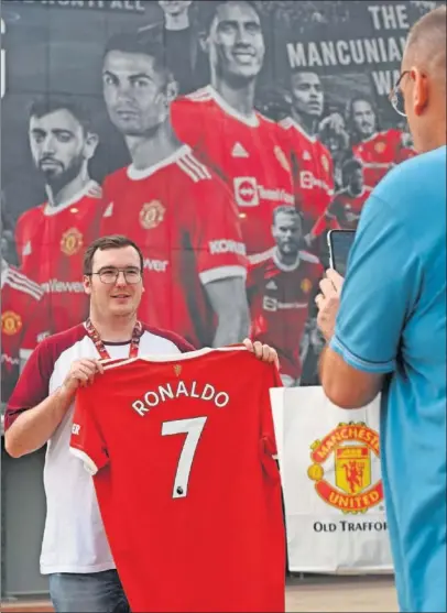  ??  ?? Un aficionado del Manchester United posa con la camiseta de Cristiano Ronaldo delante de Old Trafford.