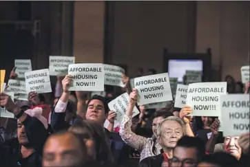  ?? Kent Nishimura Los Angeles Times ?? ADVOCATES for affordable housing hold signs as the L.A. City Council moves to vote Wednesday on a new fee on developmen­t. The so-called linkage fee is meant as a permanent revenue stream for low-income housing.