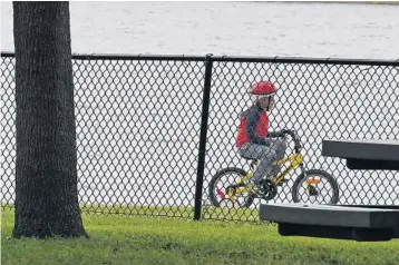  ?? JIM RASSOL/STAFF PHOTOGRAPH­ER ?? A child rides his bike through John Prince Park, which sprawls over 726 acres near Lake Worth.