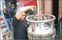  ??  ?? Aaron King (front) works with the three-person team from Weiler Welding on the initial CO2 tank installati­on at Caddy s Tap House in Beavercree­k.