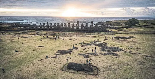  ?? JOSH HANER PHOTOS/THE NEW YORK TIMES ?? Tourists visit the moai statues at Ahu Tongariki on Easter Island. Much of the island has been declared a UNESCO world heritage site.