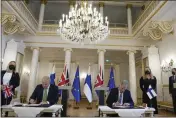  ?? FRANK AUGSTEIN — THE ASSOCIATED PRESS ?? British Prime Minister Boris Johnson, left, and Finland's President Sauli Niinisto sign a security assurance at the Presidenti­al Palace in Helsinki, Finland, on Wednesday.