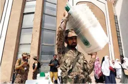  ?? FAYAZ AZIZ/REUTERS ?? SIBUK: Tentara Pakistan ikut mengusung kotak-kotak suara untuk dibawa ke TPS.