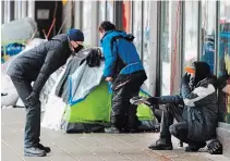  ?? RYAN REMIORZ
THE CANADIAN PRESS ?? A man chats with a homeless person at a small tent city in downtown Montreal. The total number of police service calls in the first eight months of the pandemic rose eight per cent, particular­ly for wellness checks.