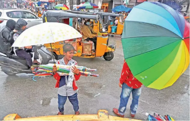  ?? Associated Press ?? ↑
A boy sells umbrellas as it rains in Hyderabad on Friday.