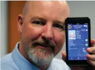  ??  ?? Ryan Williams, with the Utah Drivers License Division, displayes his cell phone with the pilot version of the state's mobile ID on Wednesday, May 5, 2021, in West Valley City, Utah. The card that millions of people use to prove their identity to everyone from police officers to liquor store owners may soon be a thing of the past as a growing number of states develop digital driver's licenses.