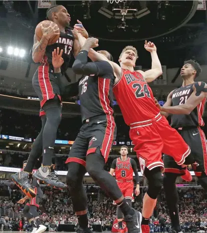  ?? GETTY IMAGES ?? Lauri Markkanen, who had 20 points, battles for a rebound with Bam Adebayo (left) and James Johnson (16) of the Heat.