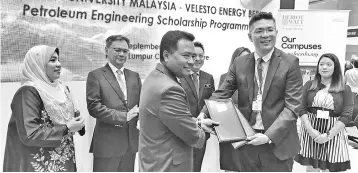  ??  ?? Wong (second right) and Rohaizad exchanging the MoU documents, witnessed by Darell (middle) during the 4th Malaysia Oil &amp; Gas Services Exhibition and Conference.