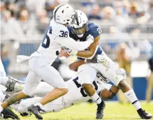  ?? ABBY DREY/TNS ?? Penn State cornerback Makai Self and defensive end Adisa Isaac try to stop running back Noah Cain during the 2019 Blue-White spring scrimmage in University Park.