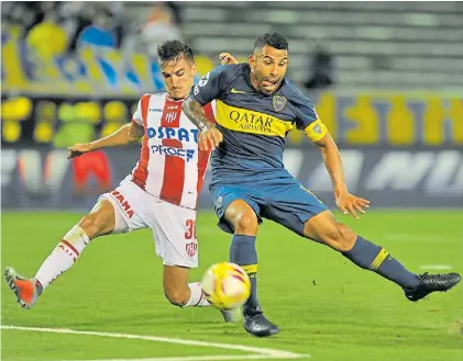  ?? M. FAILLA ?? Desteñido. Así lució Carlos Tevez el miércoles en Mar del Plata. Aquí, marcado por Mauro Pittón.