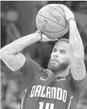  ?? STEPHEN M. DOWELL/ORLANDO SENTINEL PHOTOS ?? LEFT: Magic center Nikola Vucevic gave fans plenty to cheer about during the 2019-20 season, especially his performanc­e in the playoffs. Orlando guard D.J. Augustin shoots during a game against the Cleveland Cavaliers in 2019.
