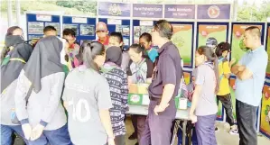  ??  ?? PARA peserta yang mengunjung­i salah satu gerai pameran diberikan taklimat oleh pegawai yang bertugas di gerai berkenaan.