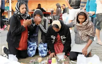  ?? JORGE SILVA REUTERS ?? FAMILY members from Fiji visit a memorial site for victims of Friday’s shooting, in front of Christchur­ch Botanic Gardens, New Zealand. |