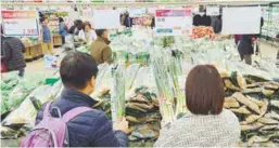  ?? REUTERSPIC ?? A couple shopping for green onions at a market in Seoul yesterday. –