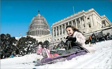  ?? OLIVIER DOULIERY/GETTY-AFP ?? A child glides across the winter wonderland left behind in Washington, D.C., on Sunday after a massive blizzard.