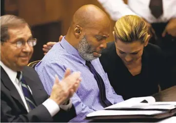  ?? CHRISTIAN GOODEN ST. LOUIS POST-DISPATCH VIA AP ?? Lamar Johnson (center) and his attorneys react Tuesday after Circuit Judge David Mason vacated his murder conviction in St. Louis, Mo. Johnson served nearly 28 years in prison for a killing he didn't commit.