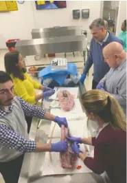  ?? BLAKE FARMER / KAISER HEALTH NEWS ?? In a lab at Lipscomb University in 2020, nurse practition­ers join doctors in practicing how to place a chest tube to fix a collapsed lung by snaking a rubber hose through a rack of pork ribs. The nurse practition­ers, who work for American Physician Partners, will have to perform the procedure under a doctor’s supervisio­n before being allowed to do it on their own.