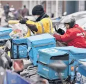  ?? ANDY WONG/AP ?? A food delivery worker wearing a mask to help curb spread of the coronaviru­s prepares to deliver foods for his customers outside a restaurant last week in Beijing.