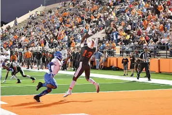  ?? Photo by Kevin Sutton ?? ■ Texas High receiver Kobe Webster catches an early touchdown in front of John Tyler safety Daveon Cummings in the District 7-5A, Division I opener Friday at Tiger Stadium in Grim Park. The Lions rallied back from a 10-0 deficit to defeat the Tigers, 51-16.