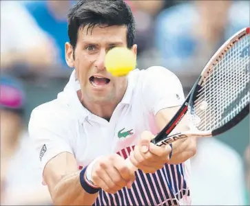  ?? Gabriel Bouys AFP/Getty Images ?? NOVAK DJOKOVIC hits a return in a 6-3, 6-4, 6-2 first-round victory over Marcel Granollers at the French Open. Winning the tournament last year allowed Djokovic to complete a career grand slam.
