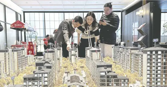  ?? ?? 龙年春节假期，一线城市楼市“以价换量”减少。图为在北京，购房者在一售楼处了解­楼盘信息 视觉中国图