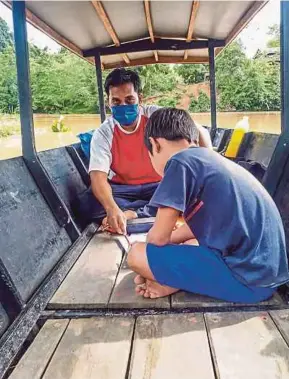  ?? (Foto BERNAMA) ?? Nasir mengajar dalam perahu berdekatan rumah muridnya di Sungai Kinabatang­an.