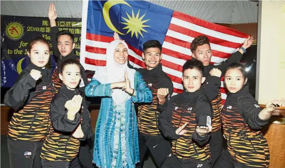  ?? — M. AZHAR ARIF / The Star ?? Up to the task: Permatang Pauh MP Nurul Izzah Anwar (fourth from left) posing with the Malaysian wushu exponents after the flag handing ceremony for the Asian Games.