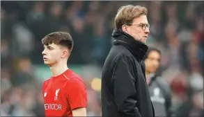  ?? ANDREW YATES / REUTERS ?? Liverpool manager Jurgen Klopp and 17-year-old striker Ben Woodburn, during the warm-up before the Reds’ FA Cup third-round stalemate with Plymouth on Sunday.