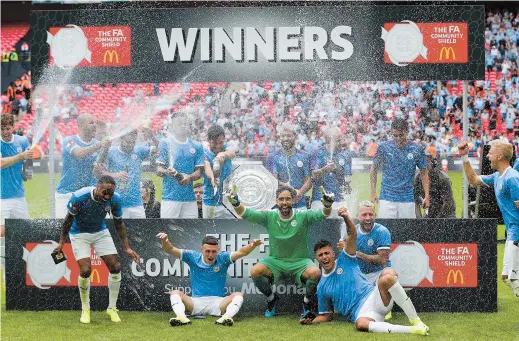  ??  ?? Manchester City players celebrate after being presented with the English FA Community Shield. City beat Liverpool on penalties after the game finished 1-1 at Wembley Stadium, London, on August 4. — AFP