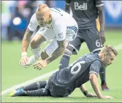  ?? DARRYL DYCK — THE CANADIAN PRESS ?? The Quakes’ Magnus Eriksson, top, tumbles over Vancouver’s Brett Levis after having the ball taken away.